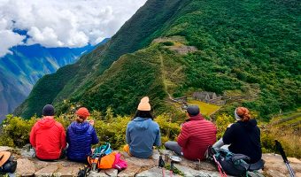 Hikers resting on a ridge with a panoramic view of the deep canyon on the Choquequirao Trek.